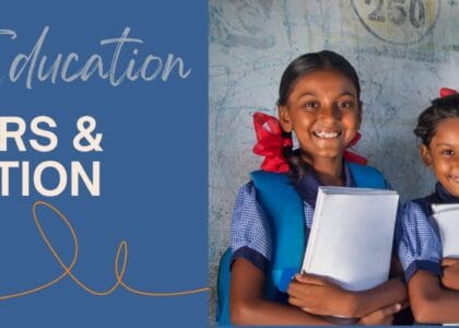 Three smiling girls holding books and notebooks, representing the article 'Barriers to Girls' Education in India.